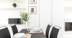 une salle à manger avec une table et des chaises noires dans l'établissement JOIVY Elegant Studio in the Centre of Milan, à Milan