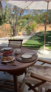 ein Holztisch mit Essen darauf mit einem Regenschirm in der Unterkunft Casa Luz in Guia + 10 Fotos