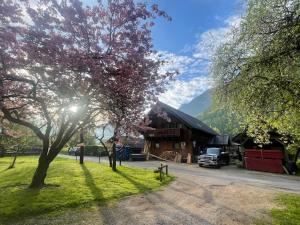 a building with a truck parked in a field with trees at Haus Bergblick in Größing