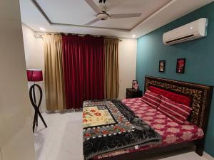a bedroom with a bed and a ceiling fan at Soundproof 2 Bed apartment in Lahore Zameen Opal in Lahore +6 photos