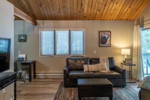 a living room with a leather couch and a tv at Escape To Ptarmigan Village 9 in Whitefish