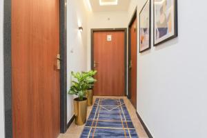 pasillo con puerta de madera y maceta en FabHotel Samrat Regency, en Udaipur