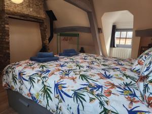 a bedroom with a bed with a floral bedspread at La Fécampette in Fécamp