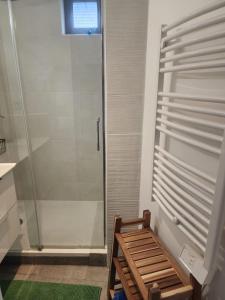 a bathroom with a shower and a wooden bench at La Fécampette in Fécamp