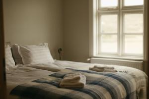 a bedroom with a bed with towels on it at Guesthouse Storu-Laugar in Laugar