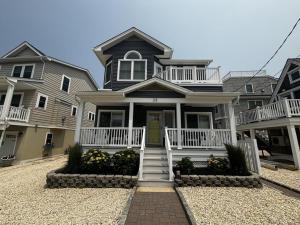 a large black house with a white porch and stairs at Wifi Decks Private Yard Beach Badges Beach Chairs Keurig Os Wd 3Rd Off The Beach in Brant Beach