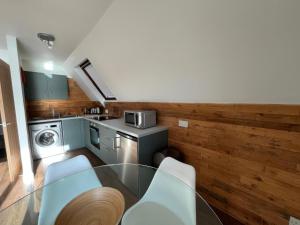 a kitchen with a glass table and chairs in a room at Glenlude - Uk50493 in Kylestrome