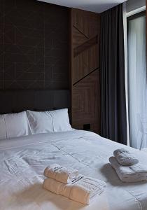une chambre avec un lit blanc avec deux serviettes dessus dans l'établissement Tara Panorama Apartment, à Kremna 6 autres photos