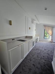 a kitchen with white cabinets and a large window at Vilnius Central House in Vilnius +21 photos