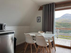 a kitchen with a white table and chairs and a window at Schiehallion - Uk50492 in Kylestrome