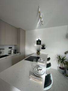 a white kitchen with a table with plates on it at Bývaj u Mari v mestskom parku s bezplatným parkovaním in Piešťany +12 photos