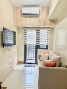 マニラにあるSoléa Suitesのソファと窓のあるリビングルーム