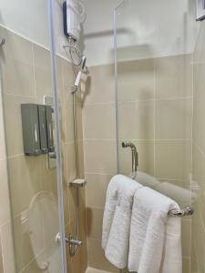 マニラにあるSoléa Suitesのバスルーム(シャワー、白いタオル付)