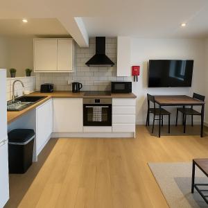 a kitchen with white cabinets and a table with chairs at Rentals Leicester 8 - Free St Parking in Leicester