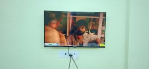 a flat screen tv hanging on a wall at A J Home Stay in Tiruvannāmalai