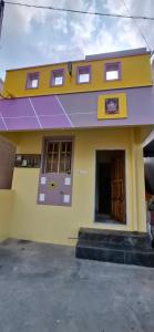a yellow house with a purple roof at A J Home Stay in Tiruvannāmalai