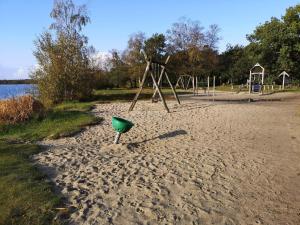 a playground with a green object in the sand at Tranquil Cottage near Kvie Lake-By Traum in Ansager