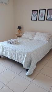 una camera da letto con un letto con un piumone bianco di Once Reinas Departamentos a San Rafael