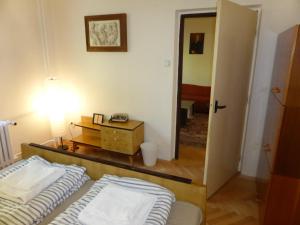 a bedroom with a bed and a table with a lamp at Retro Apartment in Brezno