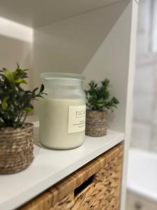 a jar of soy candle on a shelf with plants at Charmante ferme familiale in Guitalens