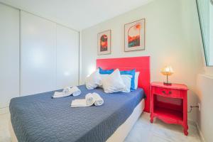 ポルティマンにあるVerde Apartments by MOJE Holidayの青いベッドと赤いナイトスタンドのある寝室