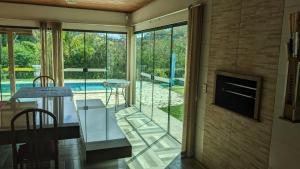 a living room with a view of a swimming pool at Sítio meu recanto in Paulo Lopes +14 photos