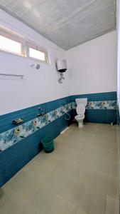 bagno con servizi igienici e pareti bianche e blu di Accomoon River Side Cottages a Dirang Dzong