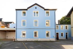 a large blue building with a parking lot at homy Lakeside Symphony in Bregenz am Bodensee in Bregenz