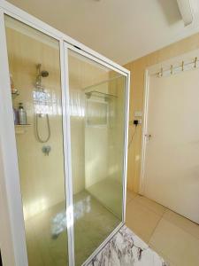 a shower with a glass door in a bathroom at Ella sweet home in Algester +13 photos