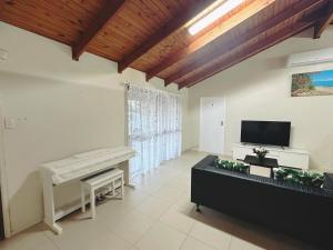 a living room with a piano and a flat screen tv at Ella sweet home in Algester