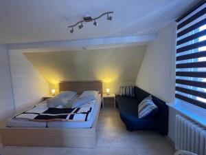 Un dormitorio con una cama y un sofá azul. en Kurze Wege, en Braunlage
