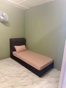 a bed in a corner of a room at Rina Hostel in Ipoh