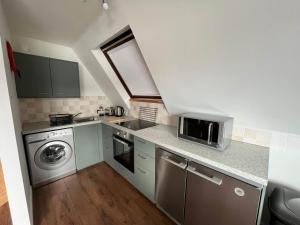 una pequeña cocina con lavadora y microondas en Ben Nevis - Uk50500, en Kylestrome