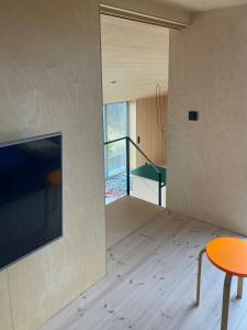 a living room with a table and a tv on a wall at Beachfront Cabin Overlooking The Coast in Hosen