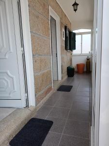 a hallway with a white door and a tile floor at Casa D'avó in Sabrosa