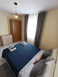 a bedroom with a blue bed with two towels on it at Casa D'avó in Sabrosa