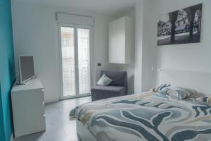 a bedroom with a bed and a chair and a television at Domò in Domodossola +15 photos
