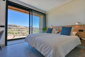 a bedroom with a large bed with a large window at La Atalaya del Salobre Golf in San Bartolomé +49 photos