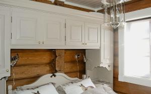 1 dormitorio con armarios blancos y 1 cama en Log Cabin By Mostertoppen Ski Stadium, en Hafjell
