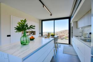 a kitchen with a counter with a large window at La Atalaya del Salobre Golf in San Bartolomé
