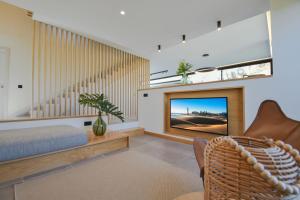 a living room with a flat screen tv and a couch at La Atalaya del Salobre Golf in San Bartolomé
