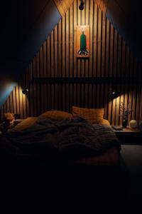 a bedroom with a large bed with a wooden wall at SpitzBergen house in Oryavchyk