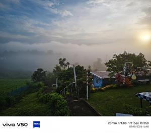 a house on the side of a hill in the fog at พูลวิลล่าminiบ้านสวนเกดกนกเขาค้อ in Phetchabun