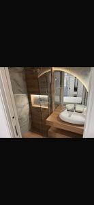 two pictures of a bathroom with a sink and a mirror at Two Residence in Satu Mare +1 photo
