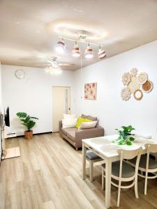 a living room with a couch and a table at D,A-House OSAKA in Osaka