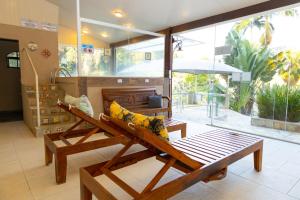 a living room with a bench and an umbrella at Pousada Reserva Penedo in Penedo