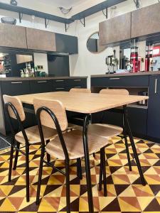 a wooden table and chairs in a kitchen at Studio 40 in Saint-Froult