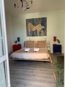 a bedroom with a bed and a painting on the wall at Casa Flavia-Residenza nel cuore di Ariccia in Ariccia +31 photos