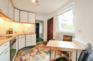 a kitchen with white cabinets and a table and a window at Stadtquartier Kiek In in Parchim