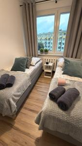 Dos camas en una habitación con una gran ventana. en LGH2-4 Schlafzimmer, voll ausgestattet, WLAN, Balkon, self-check-in, en Langenhagen